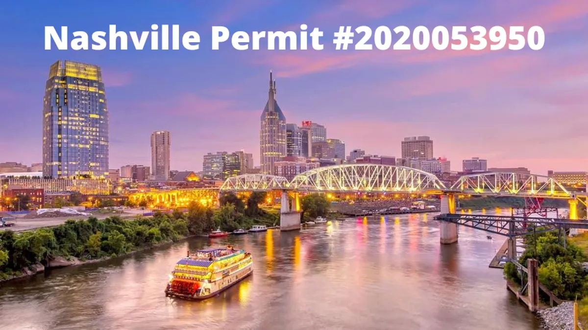 A panoramic view of the illuminated Nashville skyline at dusk, featuring a riverboat gliding along the water and the bridge connecting both banks. The festive lighting and river activity capture the city's lively spirit as day transitions to night.